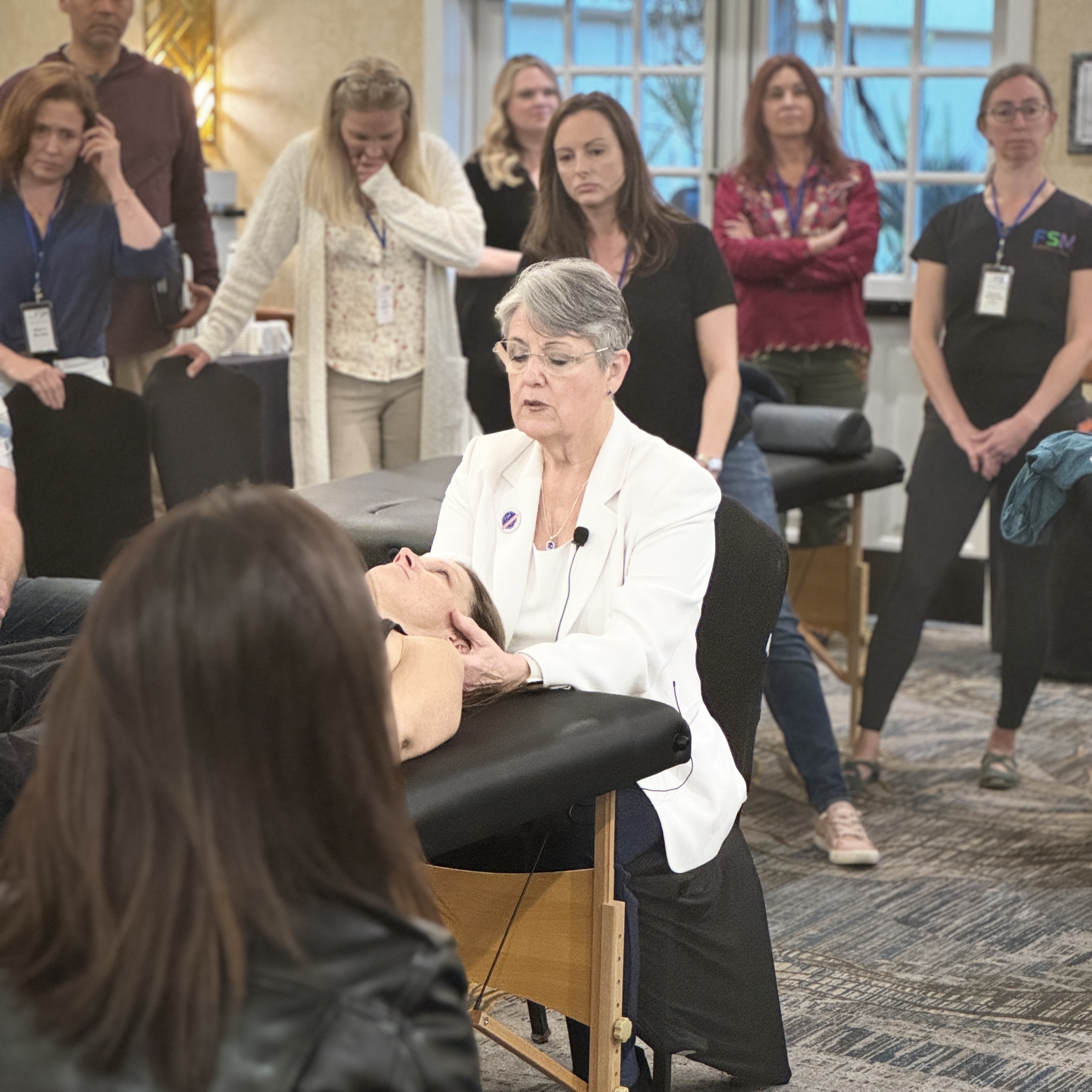 Dr. McMakin demonstrating cervical spine treatment at FSM Core seminar with practitioners observing